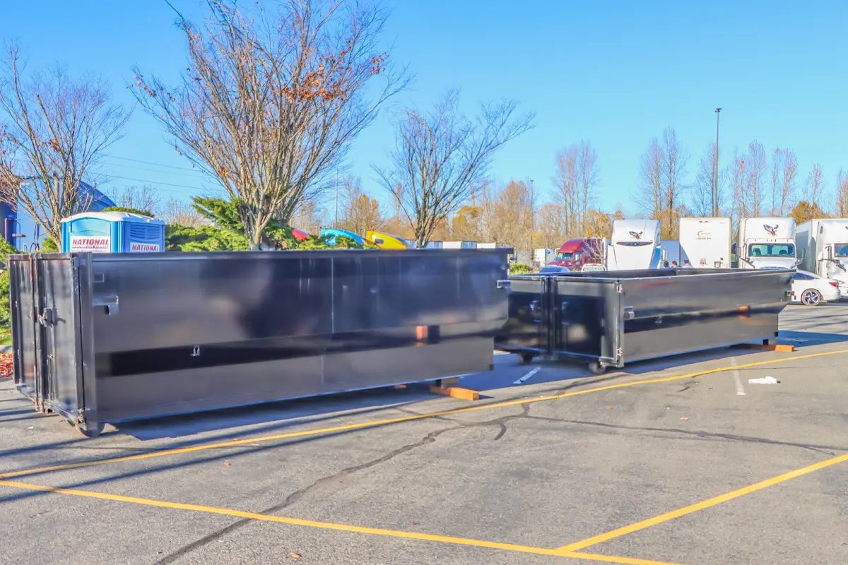 Professional dumpster rental service with roll-off container on residential driveway in South Portland